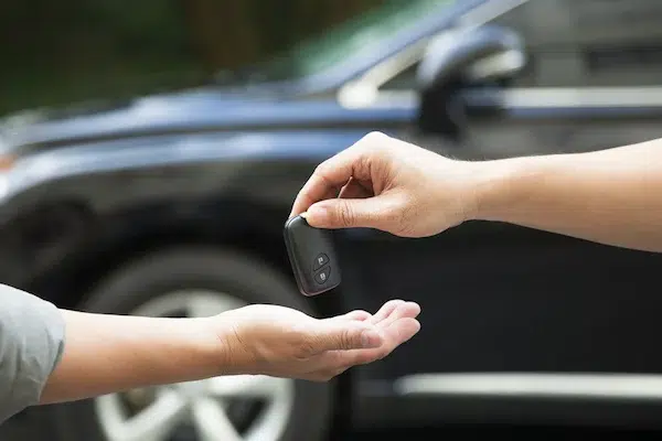 person handing over car keys